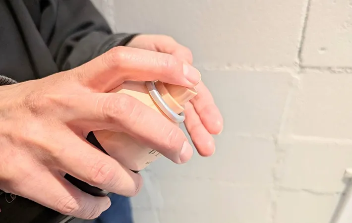 指先にスプレーをする写真