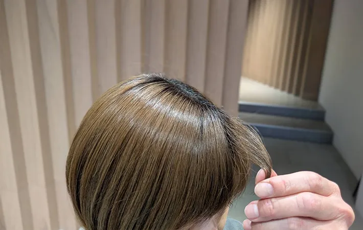 指で前髪の毛先をつまむ写真