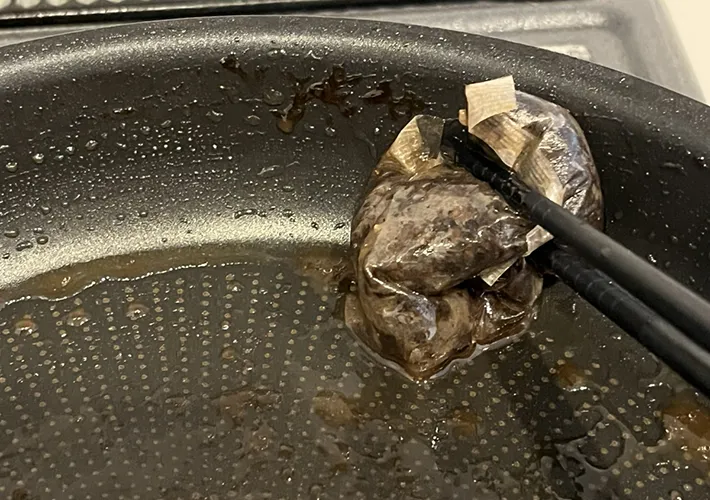 焦げつき部分をこすっている麦茶パックの写真（撮影：grapeライフハック編集部）