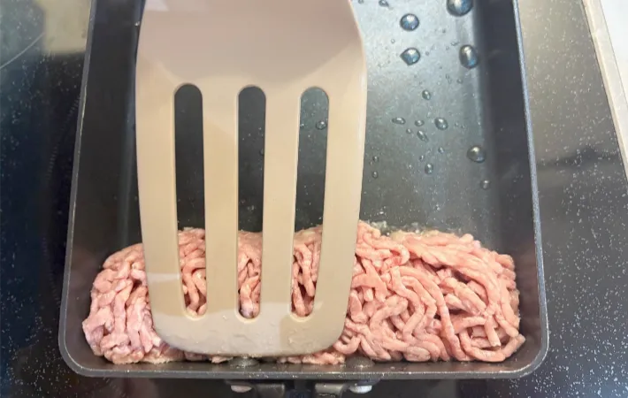 フライ返しで肉の形を整えている画像（撮影：エニママ）