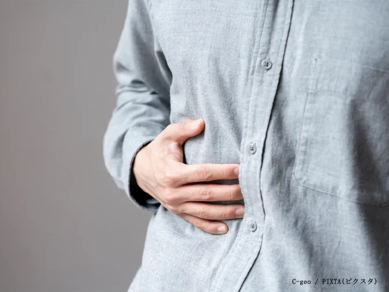 お腹を押さえる男性の写真
