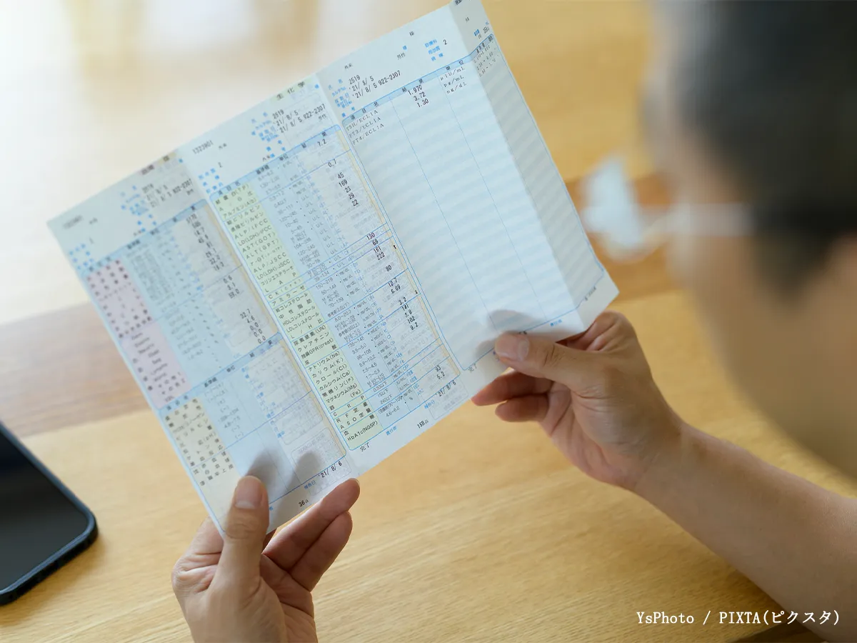 健康診断結果を見る男性の写真