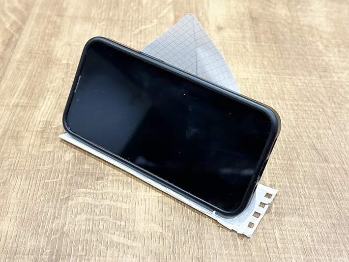 紙で作ったスマホスタンドに『iPhone 13 mini』を立てた画像（撮影：grapeライフハック編集部）