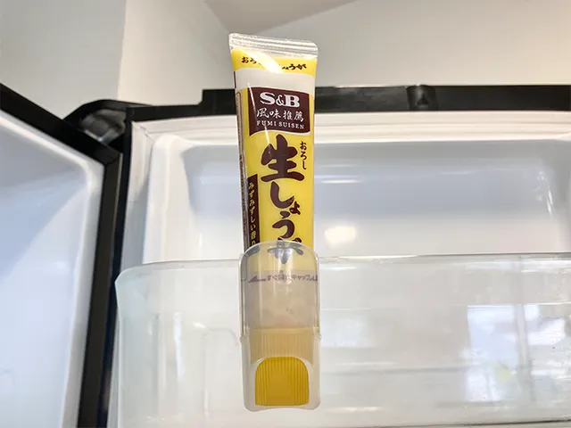 『キャンドゥ』の『薬味チューブホルダー』にショウガチューブを入れて冷蔵庫に設置した状態（撮影：grapeライフハック編集部）