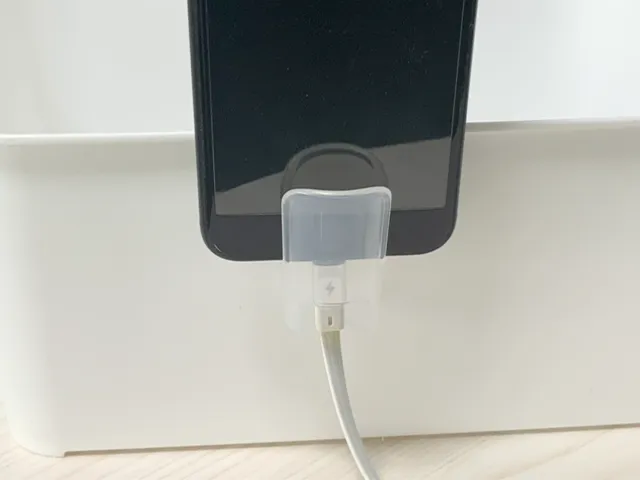 『キャンドゥ』の『薬味チューブホルダー』にスマホを入れて収納ボックスに引っかけた状態（撮影：grapeライフハック編集部）