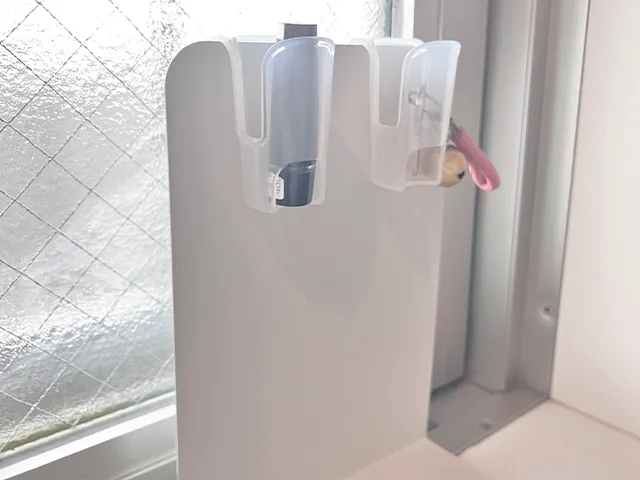 『キャンドゥ』の『薬味チューブホルダー』に判子と鍵を入れてブックエンドに引っかけた状態（撮影：grapeライフハック編集部）