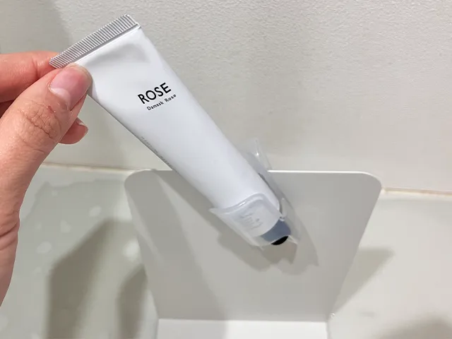 『キャンドゥ』の『薬味チューブホルダー』にハンドクリームを入れてブックエンドに引っかけた状態（撮影：grapeライフハック編集部）