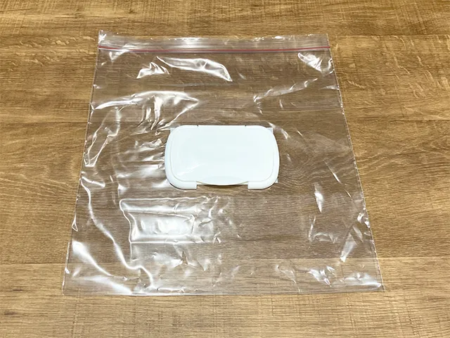 ジッパーつき保存袋の上にウェットシートの蓋を置いた状態（撮影：grapeライフハック編集部）