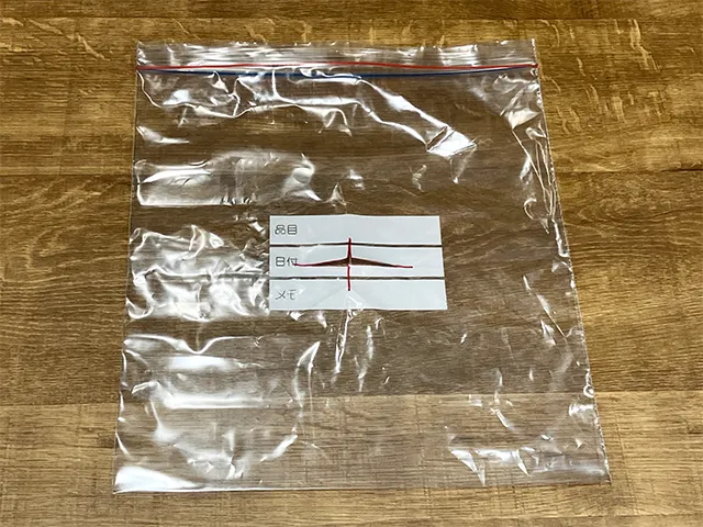 ジッパーつき保存袋の上に描いた十字を切るところ（撮影：grapeライフハック編集部）