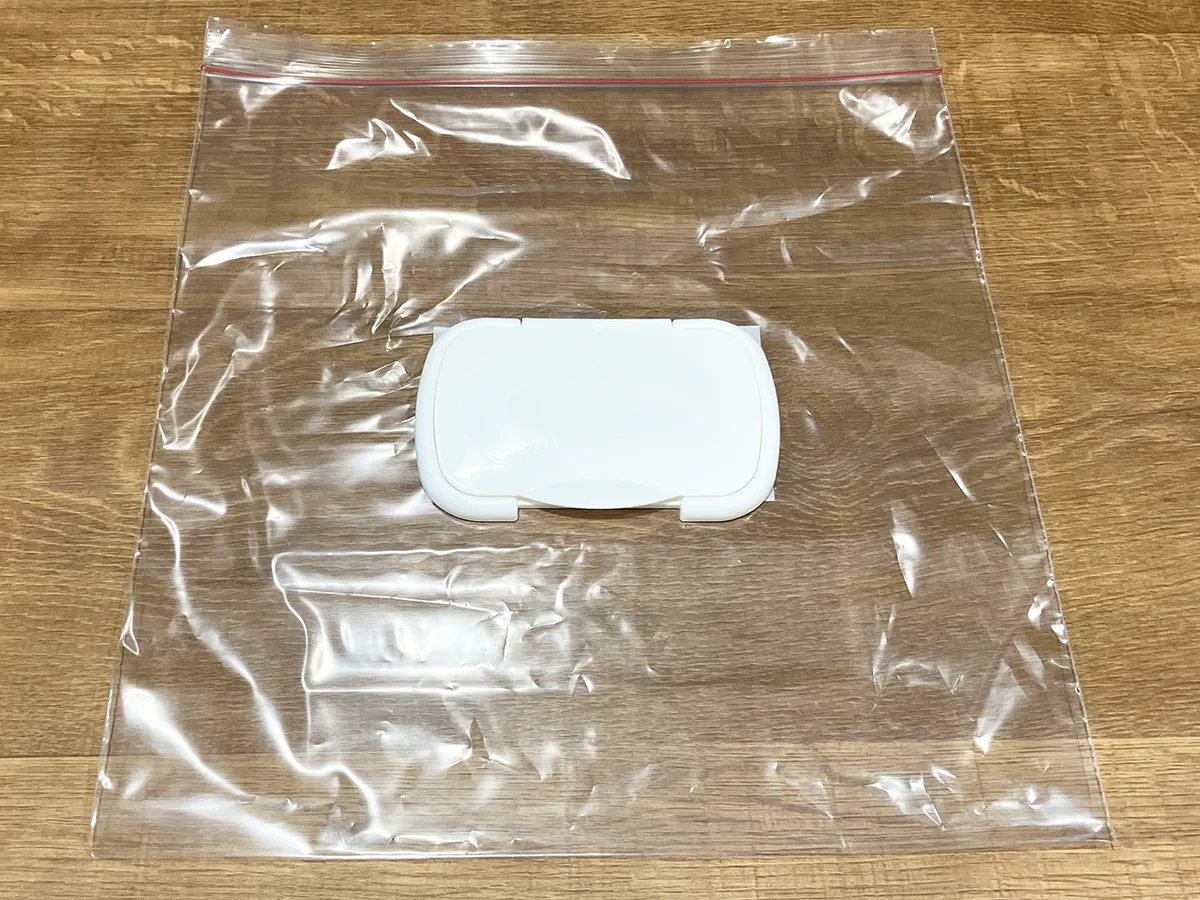 ジッパーつき保存袋の上にウェットシートの蓋を置いた状態（撮影：grapeライフハック編集部）