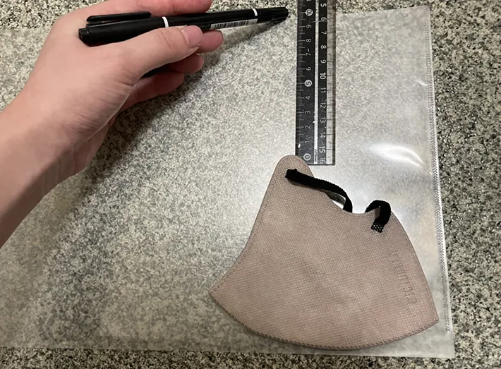 マスクをクリアファイルに重ねてサイズを測る写真（撮影：grapeライフハック編集部）