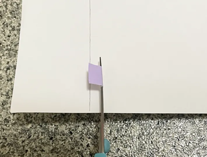 マスキングテープを貼ったハサミで紙を切る写真（撮影：grapeライフハック編集部）