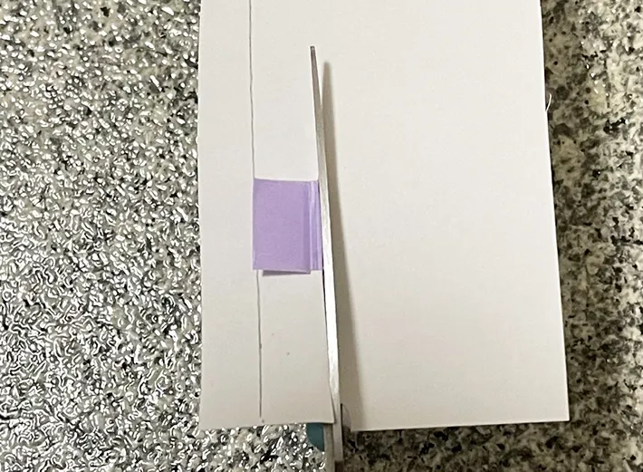 マスキングテープを貼ったハサミで紙を切る写真（撮影：grapeライフハック編集部）