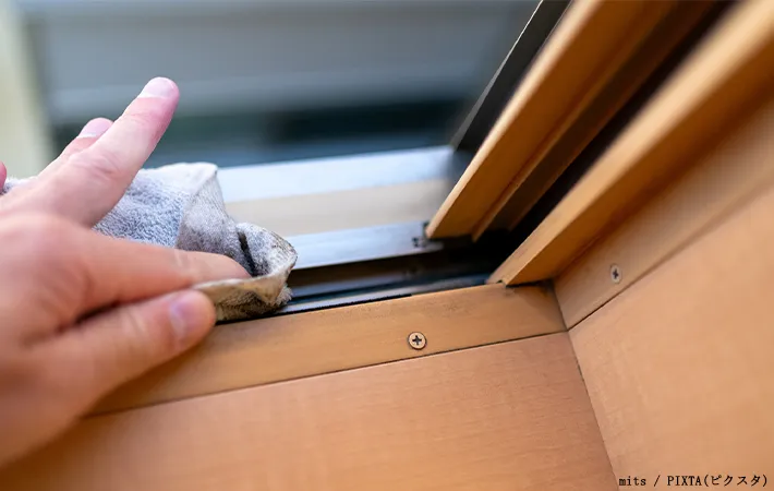 窓のサッシを掃除している写真