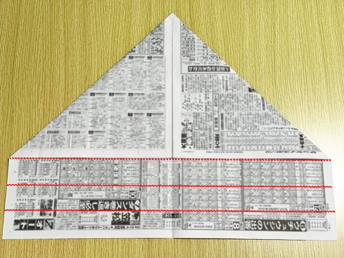 新聞紙の上1枚だけを下から3回折る線を引いた画像（撮影：grapeライフハック編集部）