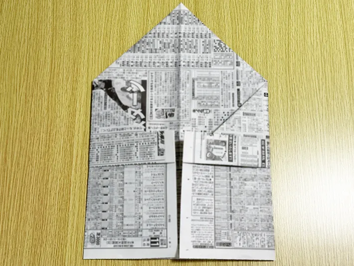 新聞紙を裏返して側面を中心に向かって折った画像（撮影：grapeライフハック編集部）