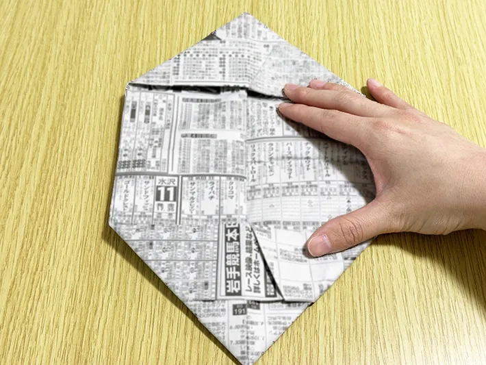 新聞紙の両端を内側に折っている画像（撮影：grapeライフハック編集部）