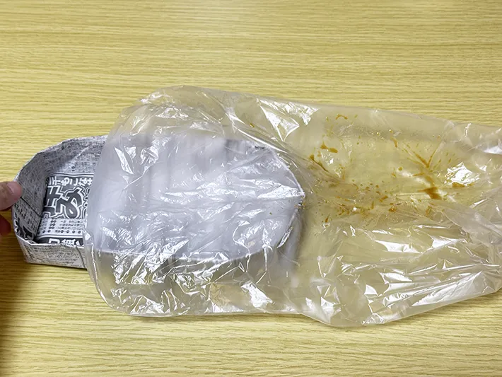 被せた『アイラップ』から新聞紙の皿をゆっくり取り外している画像（撮影：grapeライフハック編集部）
