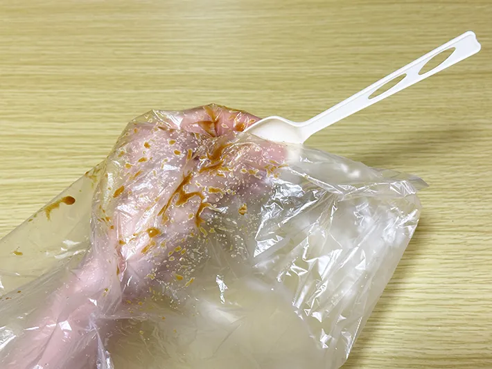 『アイラップ』の中に手を入れ、袋越しにスプーンを握っている画像（撮影：grapeライフハック編集部）