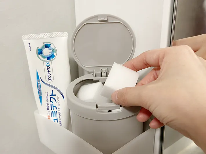 『ワンタッチ綿棒ケース』にメラミンスポンジを入れている画像（撮影：grapeライフハック編集部）