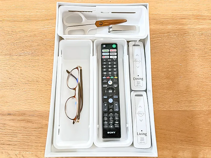 『伸縮収納トレー浅型』でリモコンやメガネを収納する写真（撮影：Classy Life）