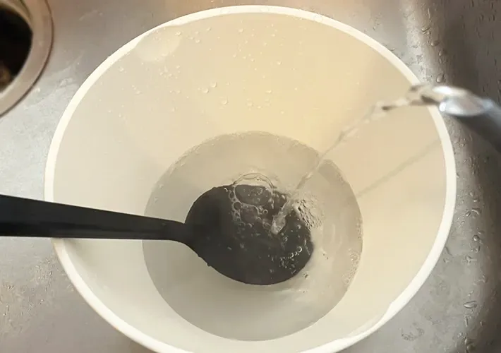 シリコンスプーンを入れたボウルにお湯を注ぐ写真（撮影：grapeライフハック編集部）