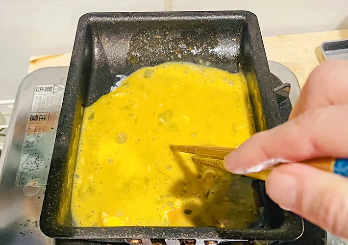 卵液を玉子焼き器で作る写真