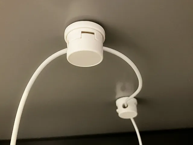 『『360°回転ケーブルクリップ』をデスクの裏側に貼った場面（撮影：grapeライフハック編集部）