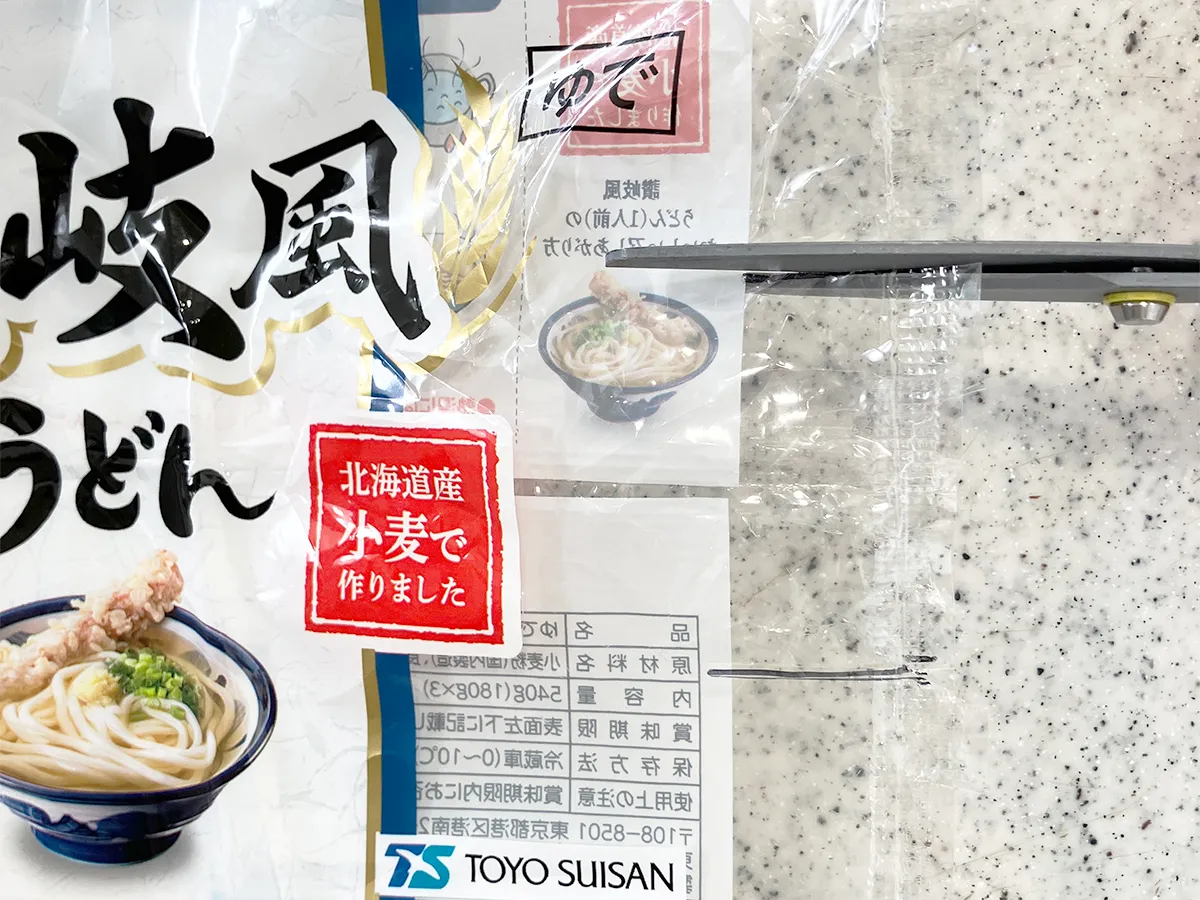 うどんの袋に切り込みを入れた場面（撮影：grapeライフハック編集部）