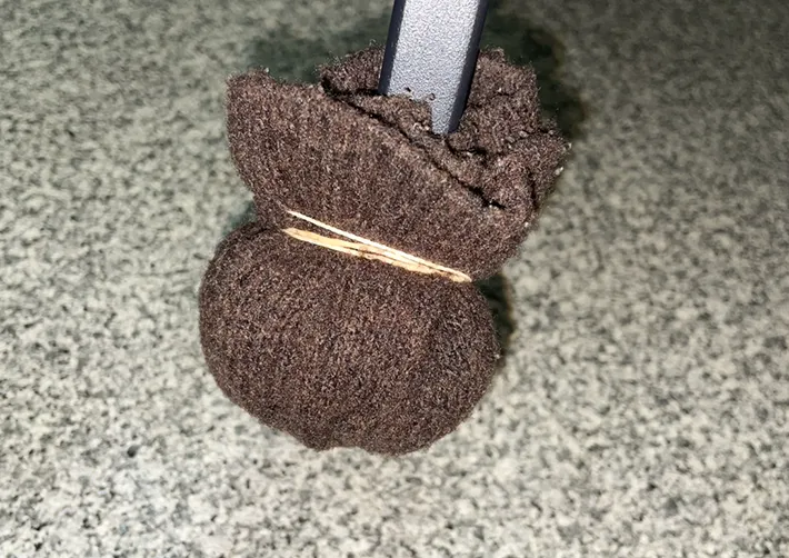 椅子の脚につけたニットの切れ端を輪ゴムで縛る写真（撮影：grapeライフハック編集部）