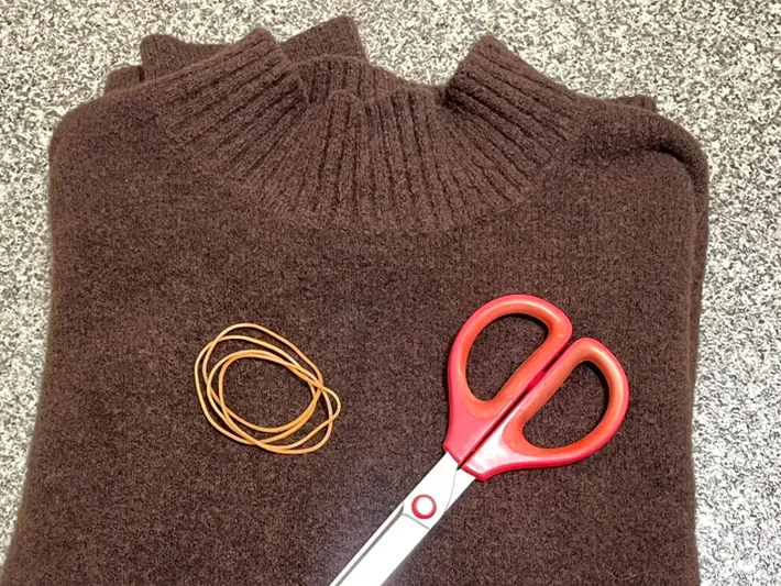 ニット、輪ゴム、ハサミの写真ニットの端を輪ゴムで結んだ写真(撮影:grapeライフハック編集部)
