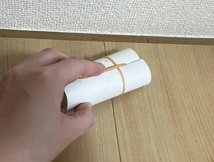 トイレットペーパーにつけた輪ゴムで床を掃除する写真（撮影：grapeライフハック編集部）