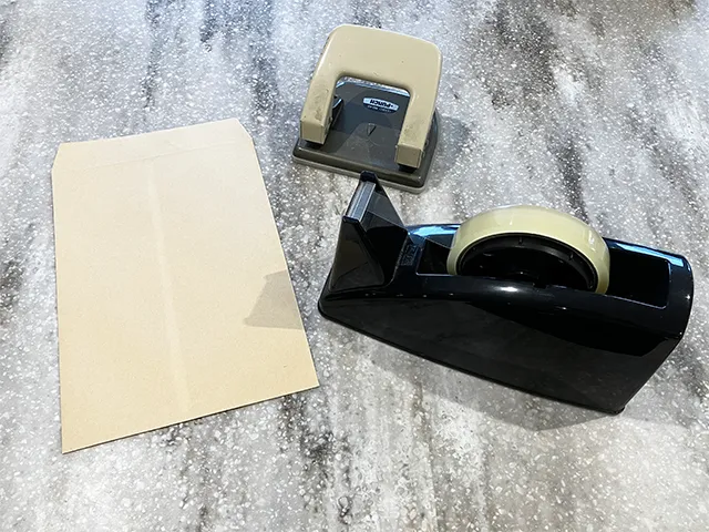 封筒、穴開けパンチ、セロハンテープを並べた場面（撮影：grapeライフハック編集部）