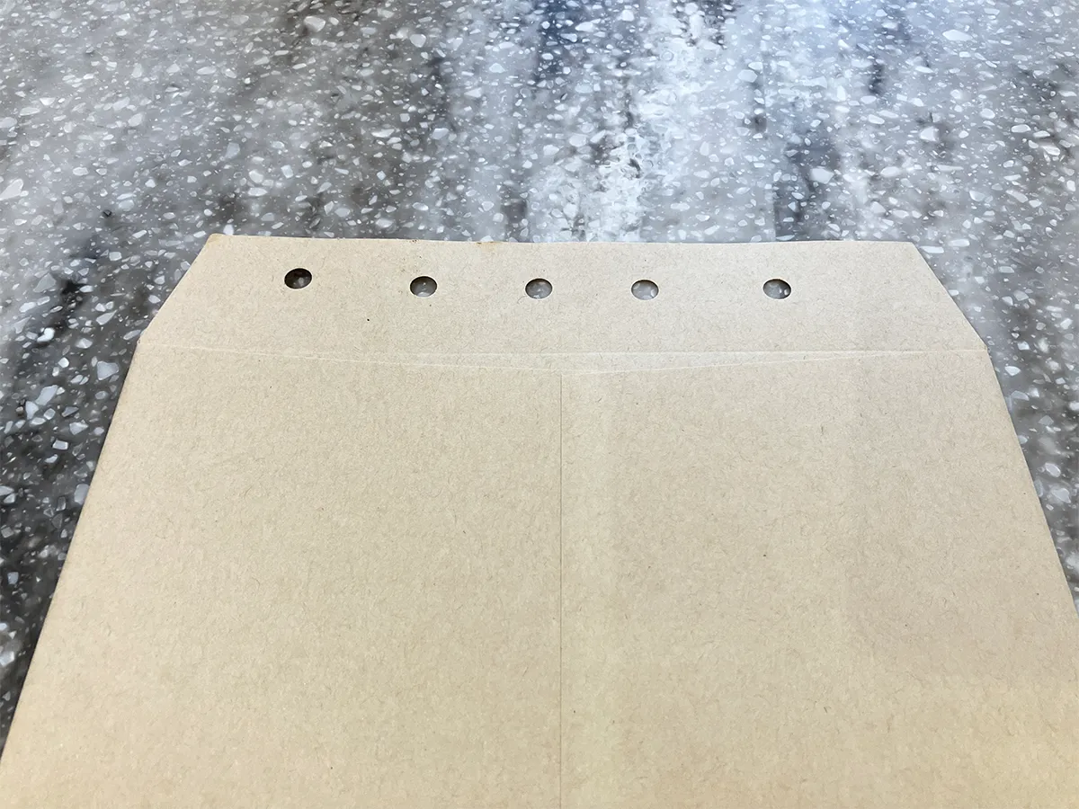 封筒に穴開けパンチで穴を開けた場面(撮影:grapeライフハック編集部)
