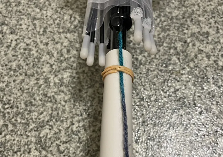 毛糸を傘の持ち手に輪ゴムで固定する写真（撮影：grapeライフハック編集部）