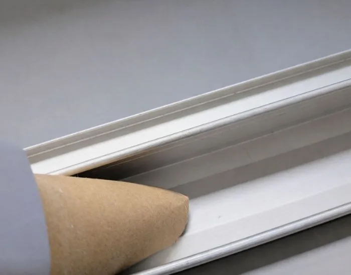 トイレットペーパーの芯で作ったノズルでサッシの溝を掃除する様子（撮影：grapeライフハック編集部）