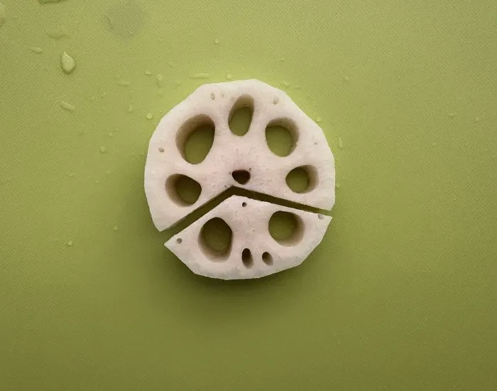 レンコンの穴を目と鼻に見立ててカットする位置を決めた様子