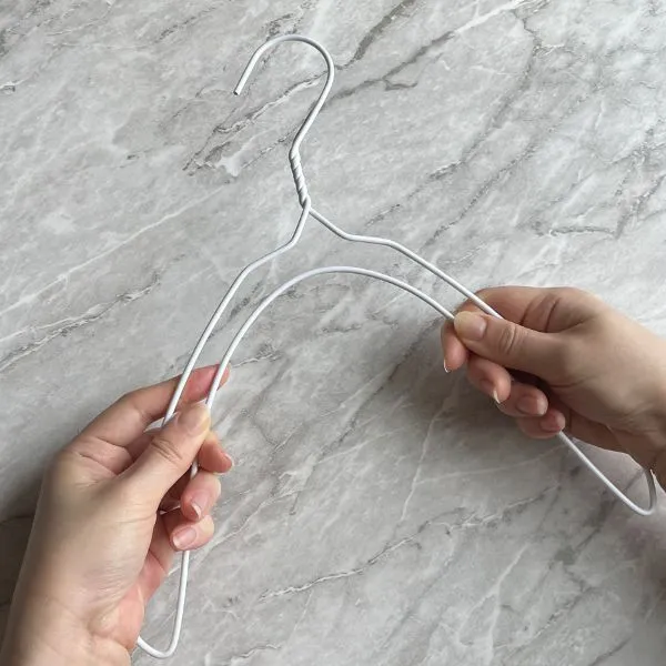 針金ハンガーの両端を下に曲げる様子（撮影：grapeライフハック編集部）