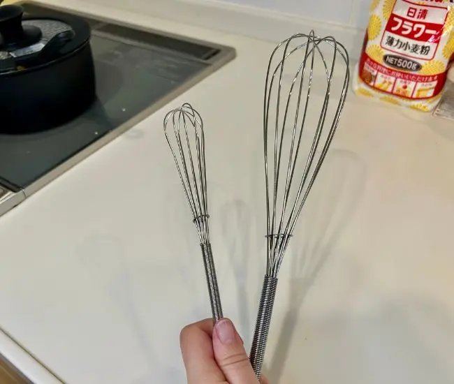 泡立て器を小麦粉の袋に入れる様子（撮影：grapeフード編集部）