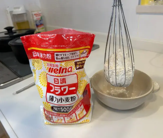 泡立て器で小麦粉を器へ移す様子（撮影：grapeフード編集部）