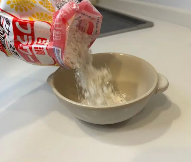 折り返した袋から小麦粉を取り出す様子（撮影：grapeフード編集部）