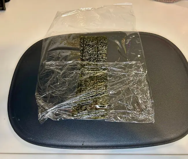 ラップを折り海苔の下半分を覆う様子（撮影：grapeフード編集部）