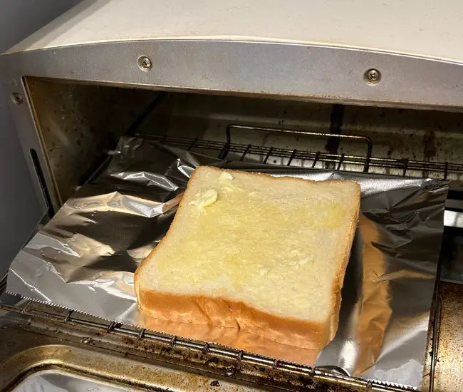 バターを塗った食パンをトーストしている様子（撮影：grapeフード編集部）