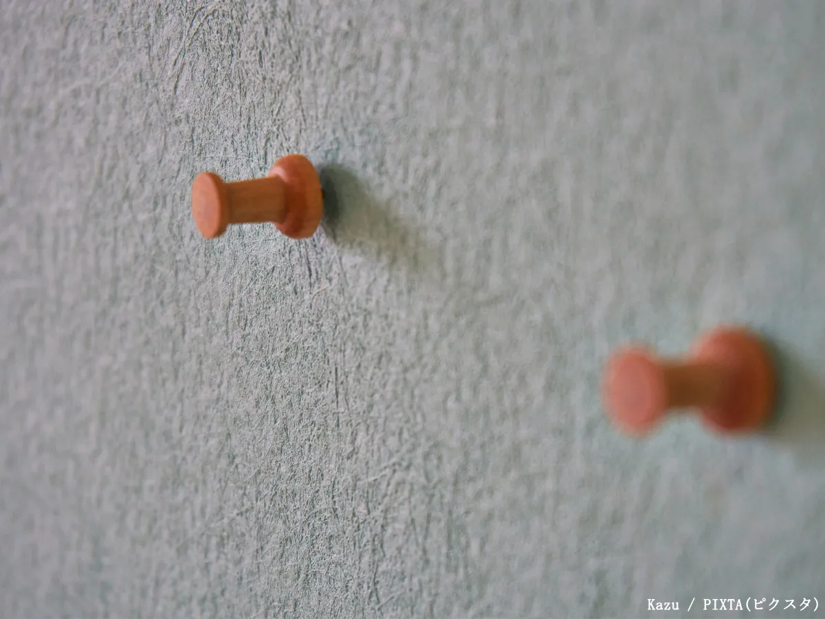 壁に画びょうを刺している写真