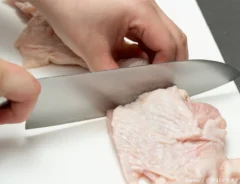 まな板で鶏肉を切る写真