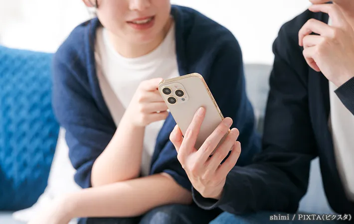 スマホを見る人の写真