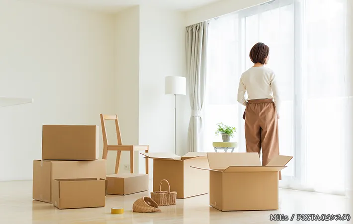 引っ越し業者を待つ女性の写真