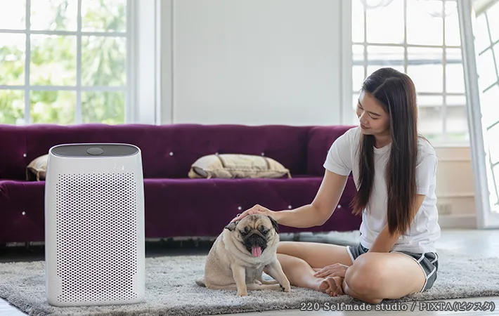 空気清浄機の横にいる女性とペットの写真