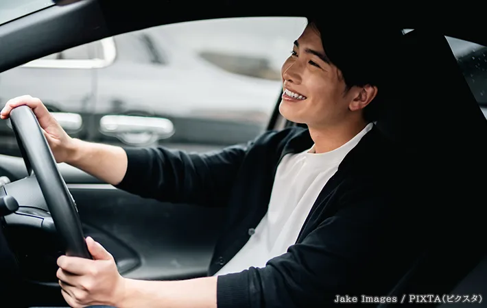 笑顔で運転する人の写真