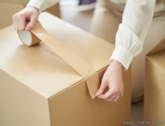 粘着テープをダンボールに貼る写真